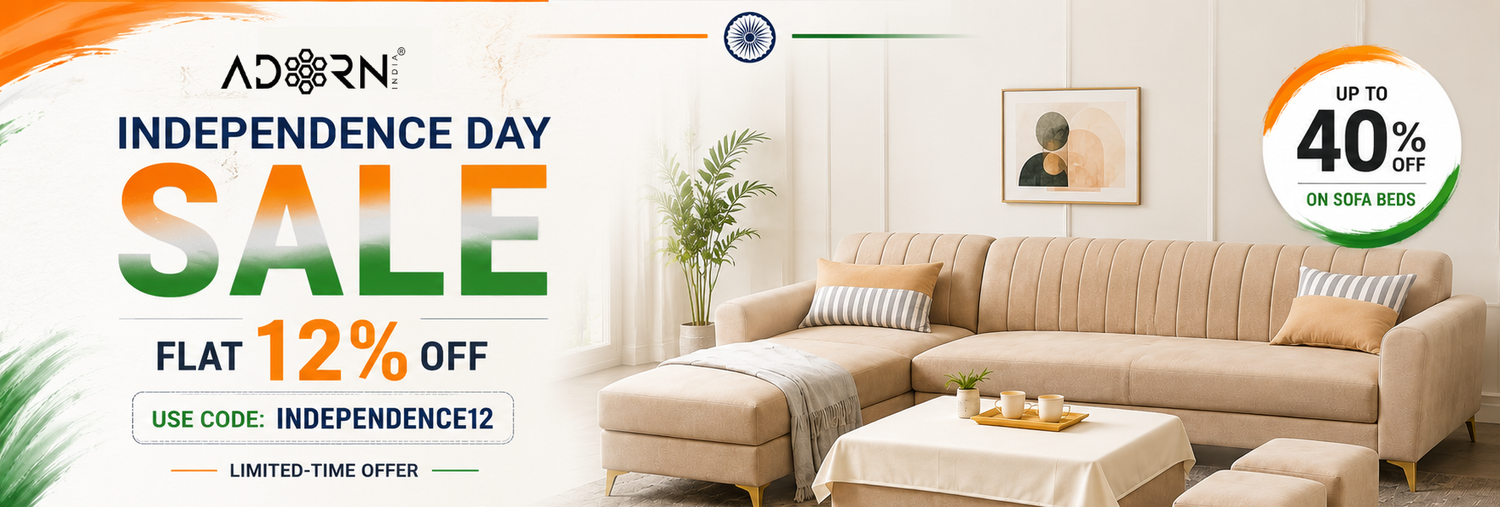 A promotional banner for Adorn Home featuring a beige sectional sofa in a bright living room, with large text reading 'Independence Day Sale' and 'Flat 12% Off,' plus a circular 'Up to 40% Off' badge.